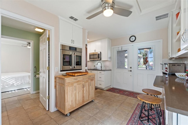 kitchen featuring white cabinetry, butcher block countertops, decorative backsplash, and refrigerator