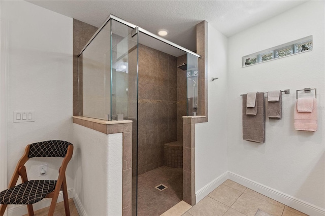 bathroom with tile patterned floors, an enclosed shower, and a textured ceiling