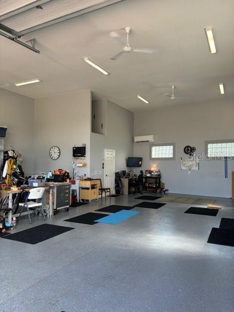 garage featuring a wall mounted AC and ceiling fan