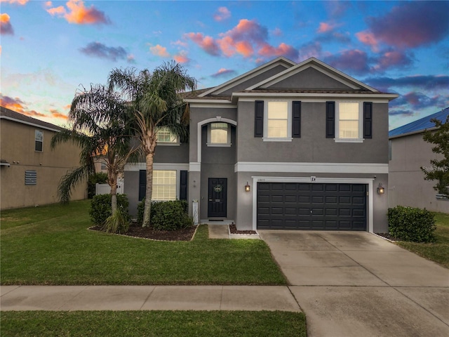 front facade with a yard and a garage