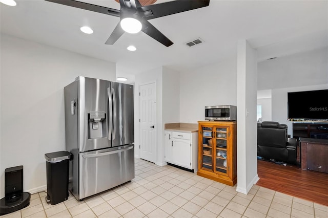 kitchen with white cabinets, stainless steel appliances, ceiling fan, and light hardwood / wood-style floors