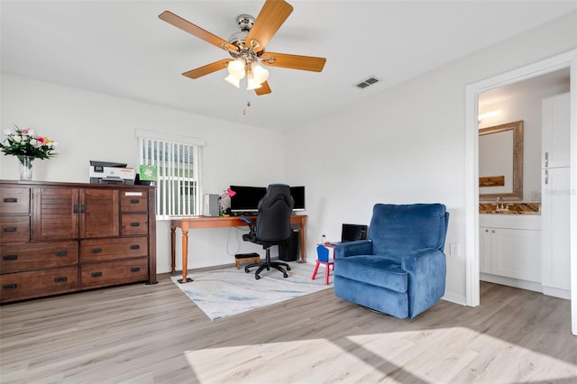 office space featuring ceiling fan, sink, and light hardwood / wood-style flooring