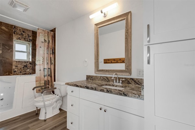 full bathroom with a textured ceiling, toilet, vanity, shower / tub combo, and hardwood / wood-style flooring