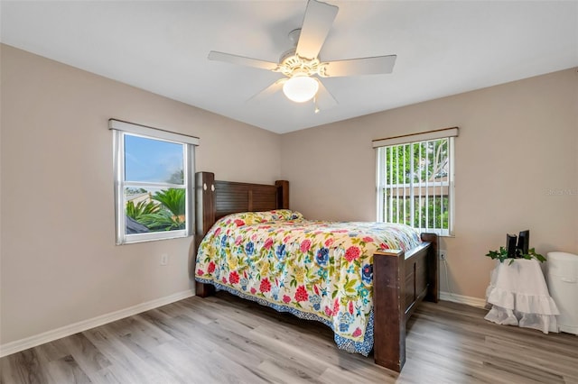 bedroom with multiple windows, ceiling fan, and light hardwood / wood-style flooring