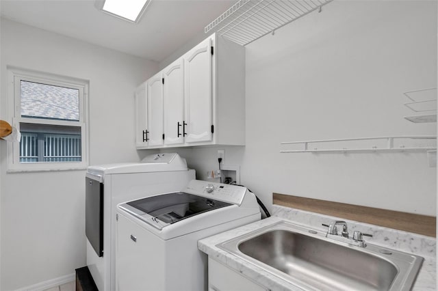 washroom with cabinets, washer and clothes dryer, and sink