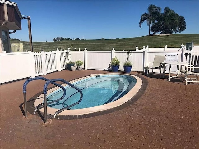 view of swimming pool with an in ground hot tub and a patio