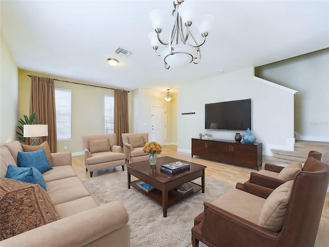 living room with a chandelier and light wood-type flooring