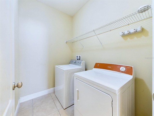 laundry area featuring separate washer and dryer and light tile patterned floors