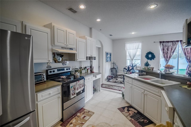 kitchen featuring white cabinetry, sink, stainless steel appliances, and a textured ceiling