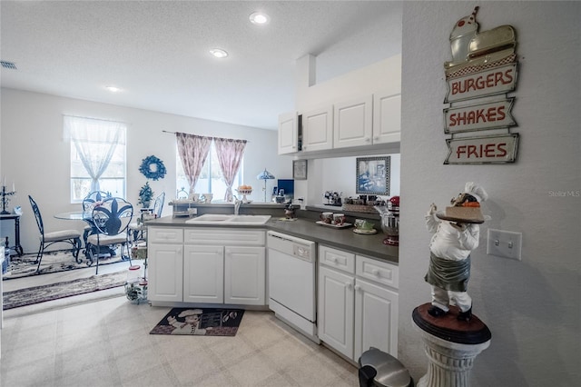 kitchen featuring kitchen peninsula, a textured ceiling, sink, dishwasher, and white cabinets