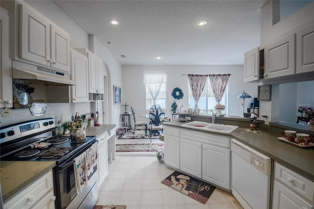 kitchen with a textured ceiling, white cabinetry, white dishwasher, and stainless steel range with electric stovetop