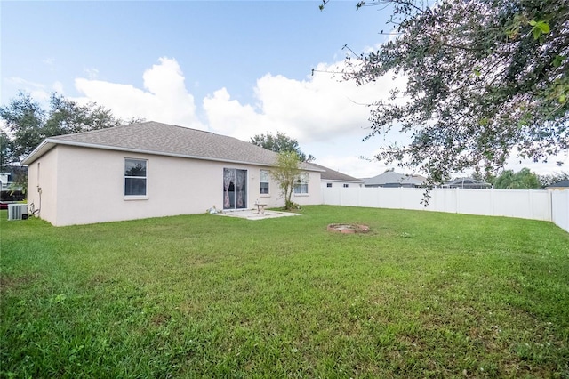 rear view of house featuring a yard and central AC