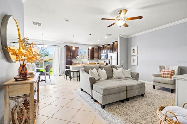 living room with ceiling fan with notable chandelier, light tile patterned flooring, a textured ceiling, and ornamental molding