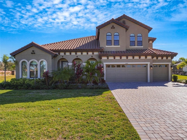 10469 Meadowrun Dr, Lithia, FL 33547 - mediterranean / spanish-style home with decorative driveway, stucco siding, a front yard, a tile roof, and an attached garage