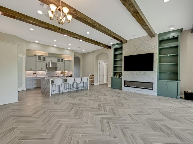 living room with light parquet floors, beam ceiling, sink, and a chandelier