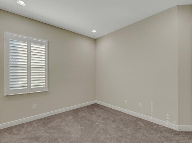 unfurnished room featuring light carpet