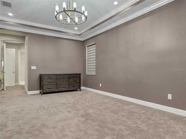 unfurnished bedroom featuring a chandelier, light colored carpet, a raised ceiling, and crown molding