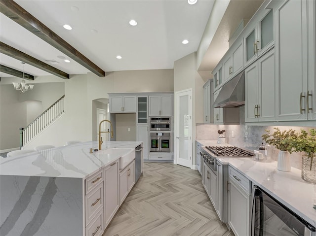 kitchen with sink, stainless steel appliances, wine cooler, light stone counters, and light parquet floors