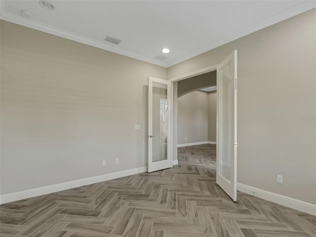 spare room with parquet flooring, french doors, and ornamental molding