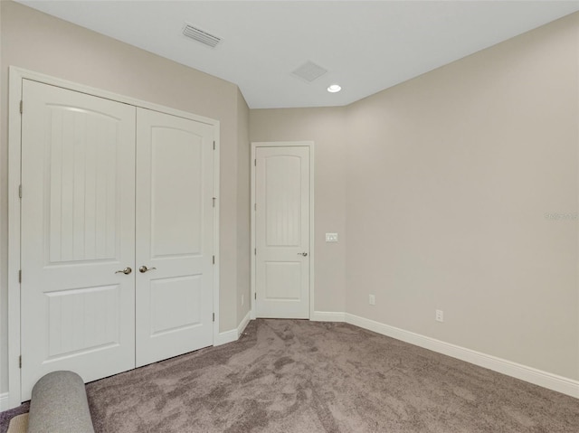 unfurnished bedroom featuring carpet flooring and a closet