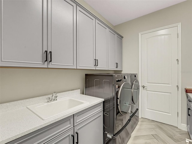 laundry area with cabinets, separate washer and dryer, sink, and light parquet floors