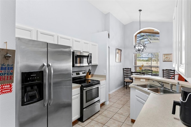 kitchen with appliances with stainless steel finishes, light tile patterned floors, high vaulted ceiling, white cabinets, and hanging light fixtures