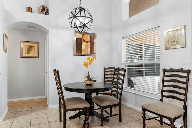 tiled dining area featuring a notable chandelier