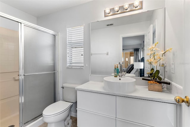 bathroom with vanity, toilet, a wealth of natural light, and a shower with shower door