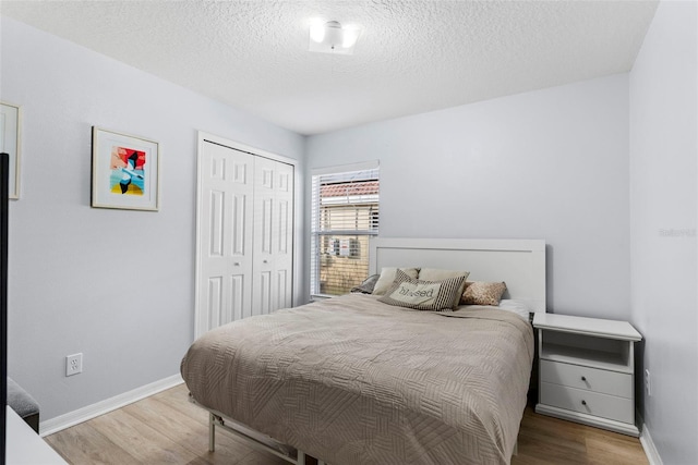 bedroom with hardwood / wood-style flooring, a textured ceiling, and a closet