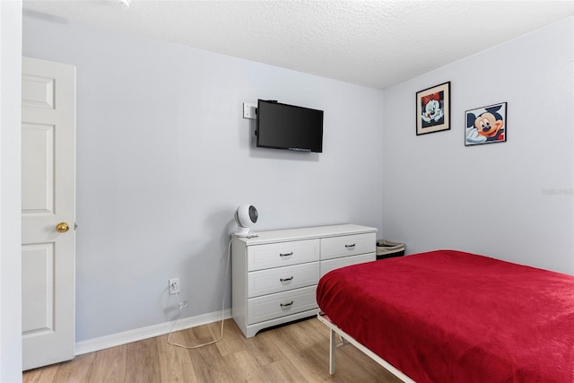 bedroom with light hardwood / wood-style flooring and a textured ceiling