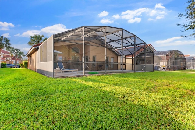 rear view of property featuring glass enclosure and a yard