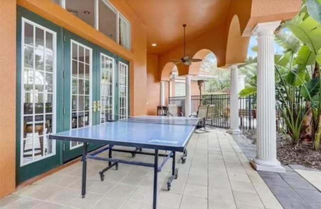 playroom with tile patterned flooring, ceiling fan, plenty of natural light, and ornate columns