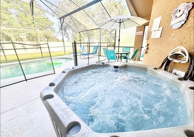 view of pool featuring glass enclosure, a patio, and a hot tub