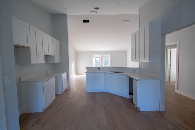 kitchen featuring white cabinets, light wood-type flooring, and kitchen peninsula