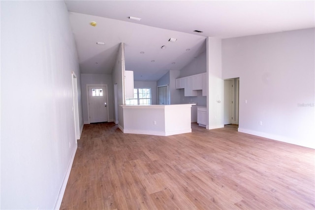 unfurnished living room featuring high vaulted ceiling and light hardwood / wood-style flooring