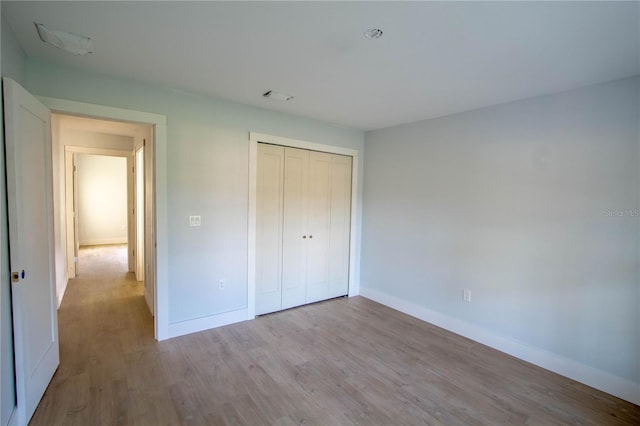 unfurnished bedroom with a closet and light hardwood / wood-style flooring