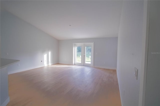 spare room with french doors and light hardwood / wood-style floors