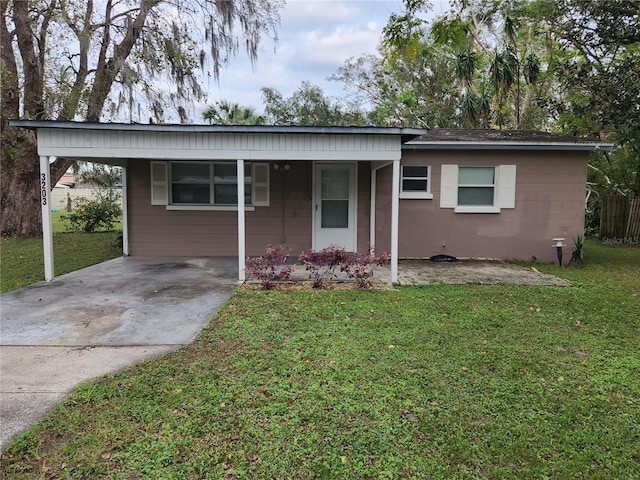 ranch-style home featuring a carport and a front yard