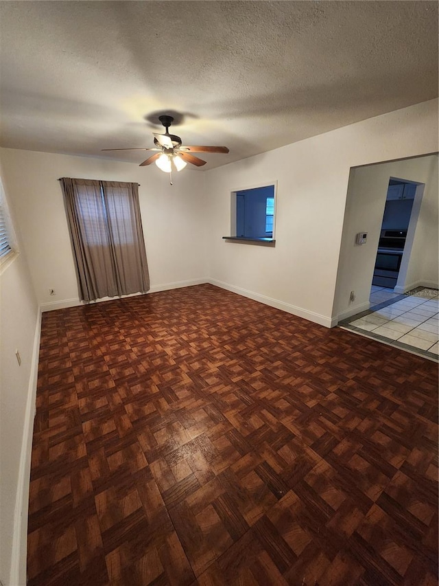 spare room with parquet flooring, a textured ceiling, and ceiling fan