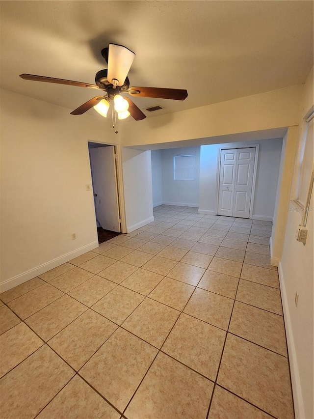 unfurnished room with ceiling fan and light tile patterned flooring