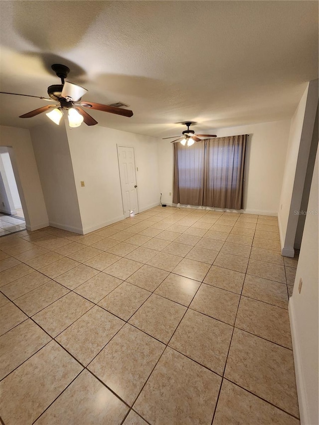 tiled empty room featuring a textured ceiling and ceiling fan