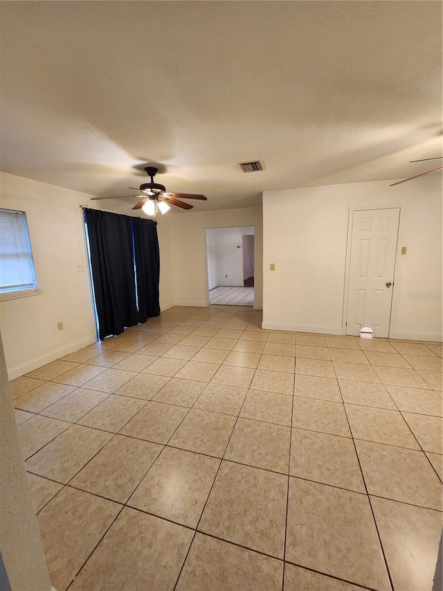 tiled empty room featuring ceiling fan