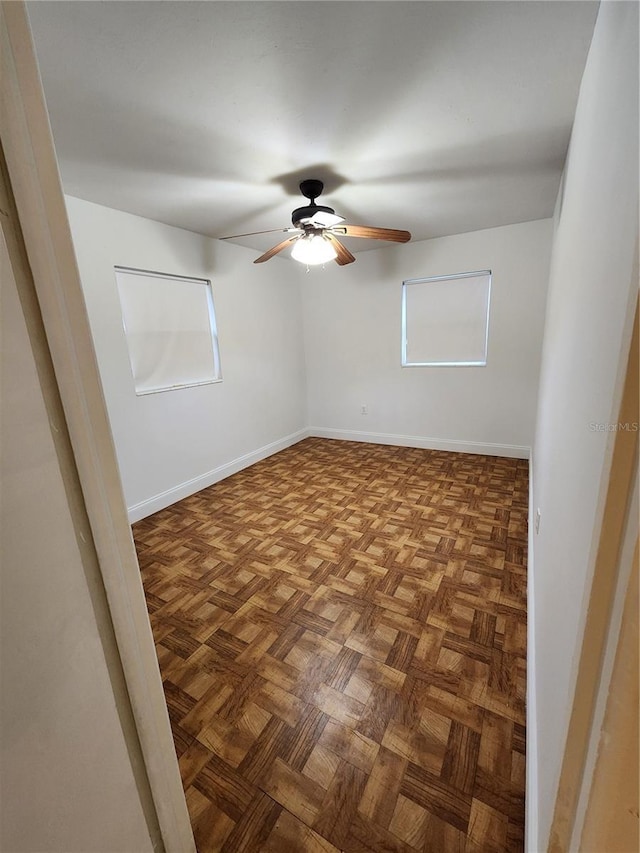 unfurnished room with parquet floors and ceiling fan