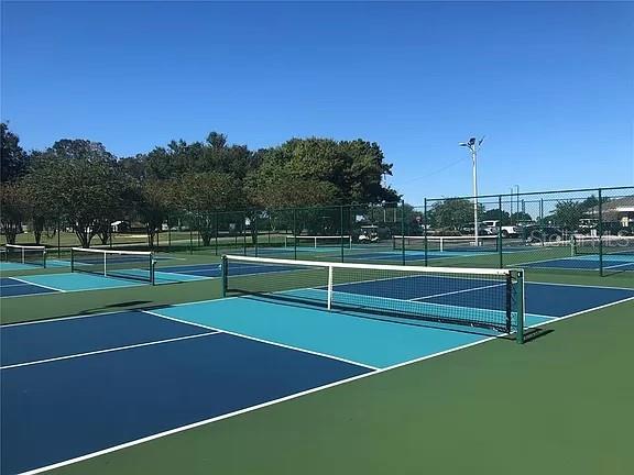 view of tennis court featuring basketball hoop