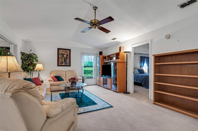 carpeted living room featuring a textured ceiling, ceiling fan, and lofted ceiling