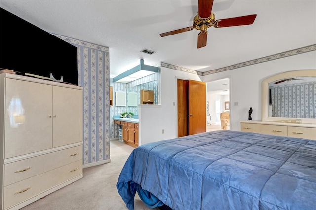 carpeted bedroom featuring ensuite bathroom and ceiling fan