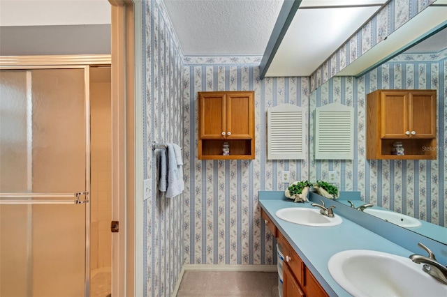 bathroom featuring a textured ceiling, vanity, and an enclosed shower