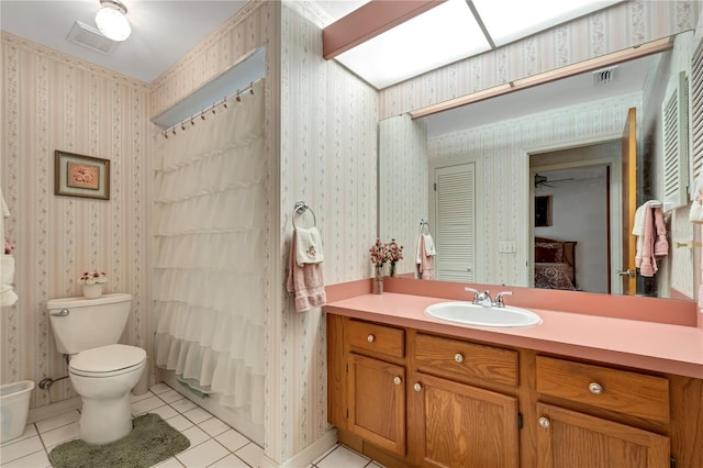 full bathroom featuring tile patterned floors, shower / bath combo with shower curtain, vanity, and toilet