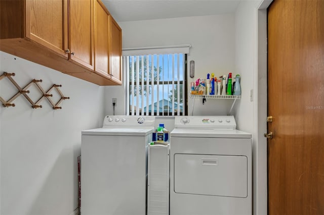 washroom with cabinets and washing machine and clothes dryer