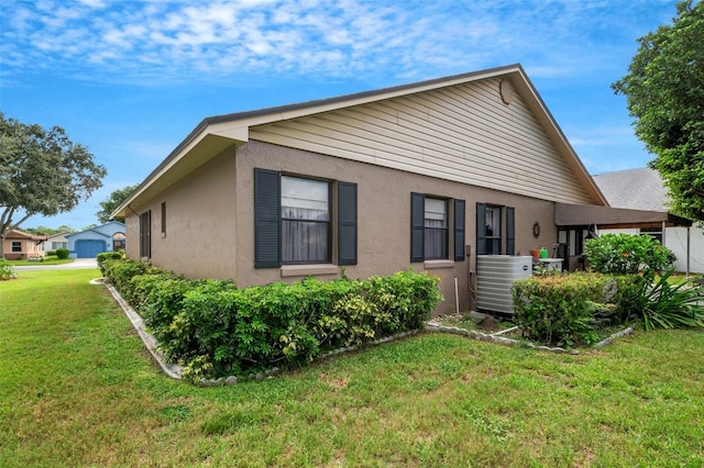 view of home's exterior with a lawn and central AC unit